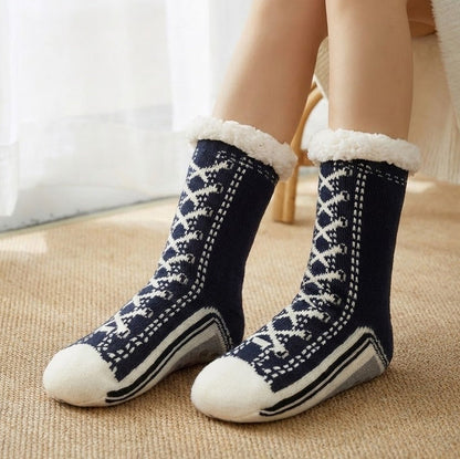 Fleece-lined sneaker-style slipper socks – navy pair on a rug