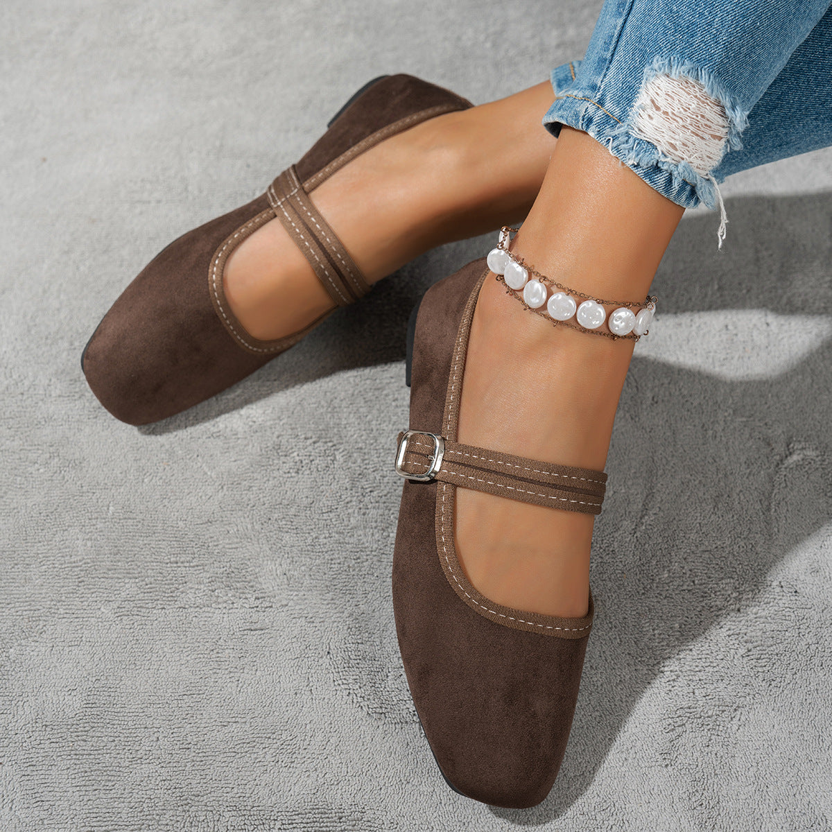 Dark brown women's Mary Jane flats with buckle straps, top view on feet