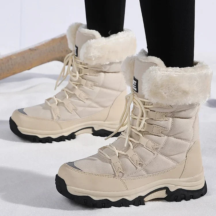Beige lace-up winter boots with cream fleece cuffs worn on snowy ground