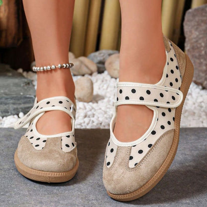 Beige women's Mary Jane trainers with black polka dots and broad straps, front view on feet