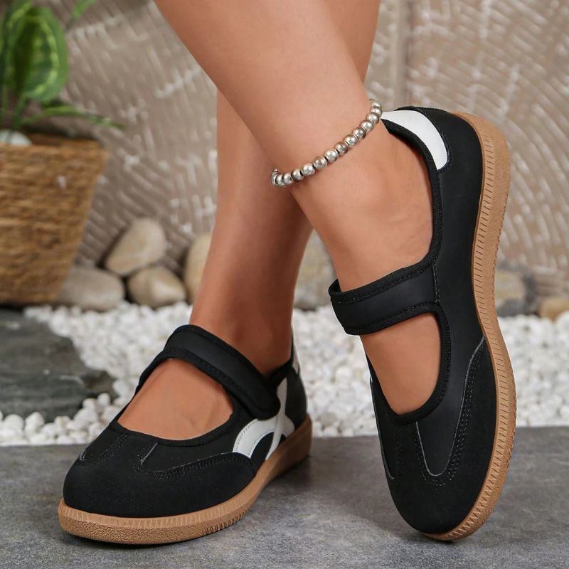Black women's Mary Jane trainers with gum soles, front view on feet