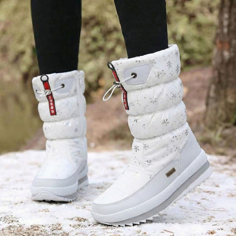 Auldweave women's waterproof mid-calf snow boots – white snowflake pair worn from the front in snow