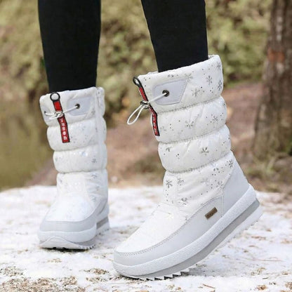 Auldweave women's waterproof mid-calf snow boots – white snowflake pair worn from the front in snow