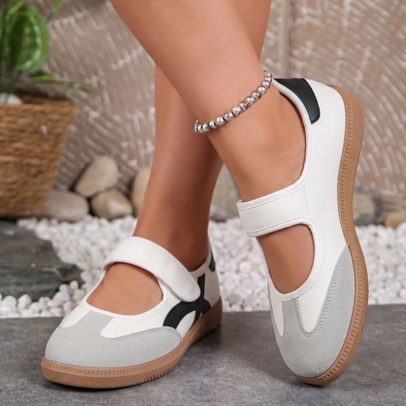 White and grey women's Mary Jane trainers with adjustable straps, front view on feet