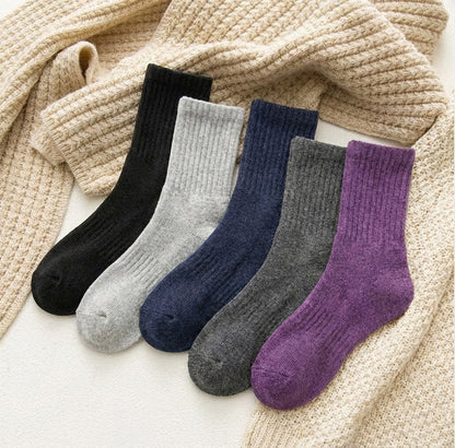 Five-pair winter crew socks – colour assortment beside a knitted blanket