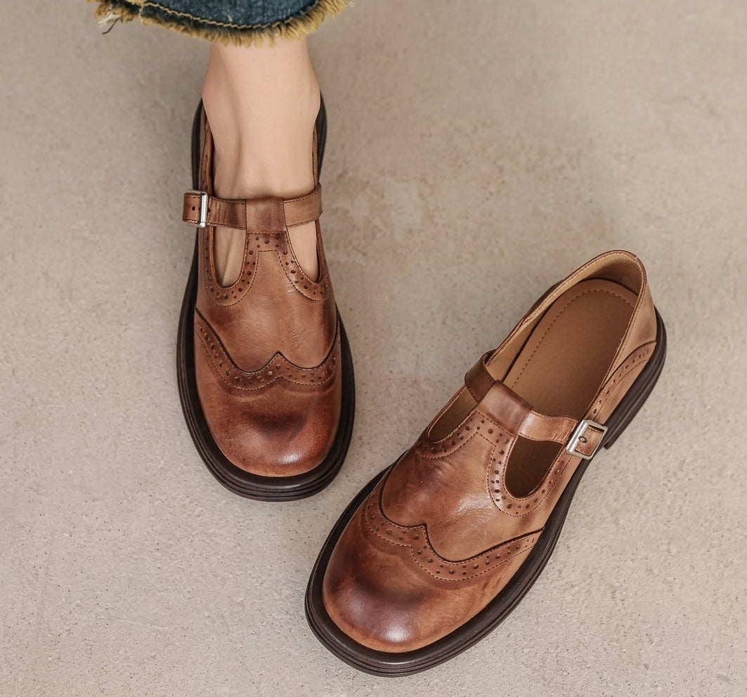 Brown women's Mary Jane brogues showing wingtip perforations and adjustable straps from above