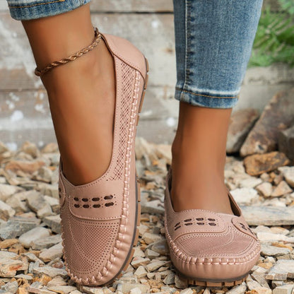 Blush pink women's perforated leather loafers with stitched edges, front view on feet
