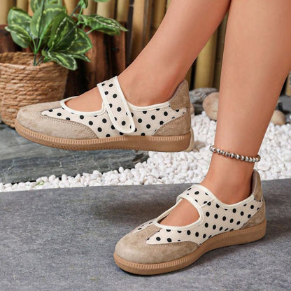 Beige polka-dot women's Mary Jane trainers with adjustable straps, side view on feet