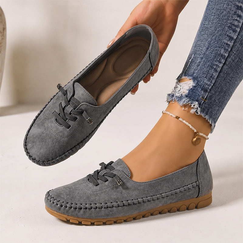 Dark grey women's suede loafers showing the shaped insole and decorative lacing