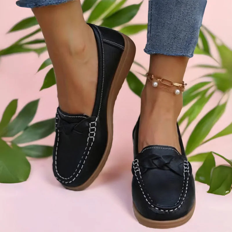 Black loafers for women with braided vamp detail, styled top-down view
