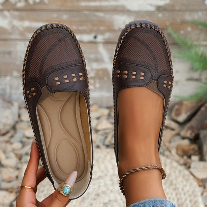 Dark brown women's perforated leather loafers showing the shaped insole and slip-on opening