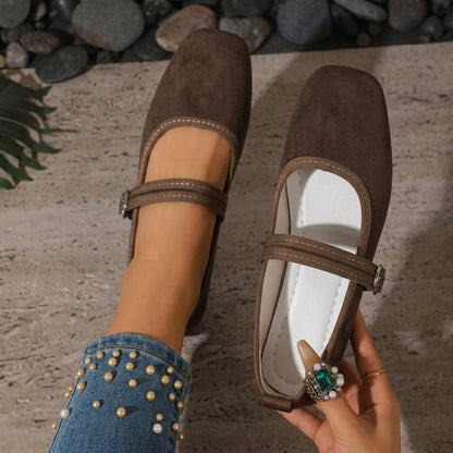Dark brown women's Mary Jane flats showing the buckle strap and pale lining
