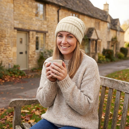 Cable-knit winter beanie – cream beanie worn outside a stone building