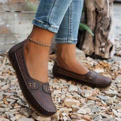 Dark brown women's wide fit leather loafers with stitched edges, side view on feet
