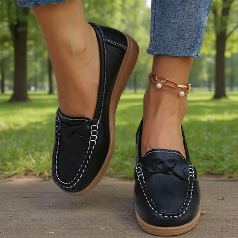 Black loafers for women with braided vamp detail, on-foot park view