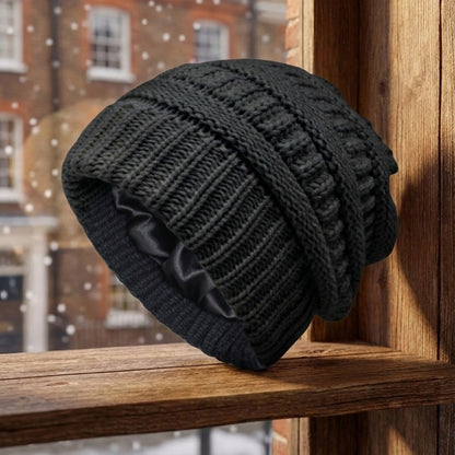 Cable-knit winter beanie – black beanie on a wooden stool