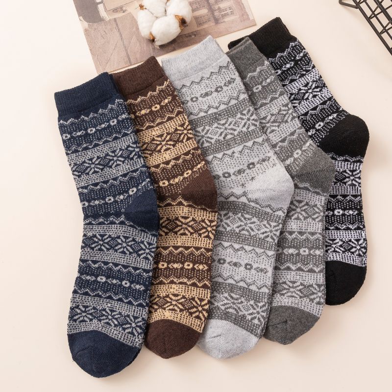 Five-pair Nordic-pattern winter socks – dark patterned pairs beside a scarf