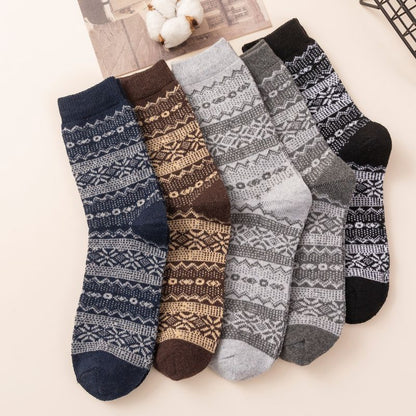 Five-pair Nordic-pattern winter socks – dark patterned pairs beside a scarf