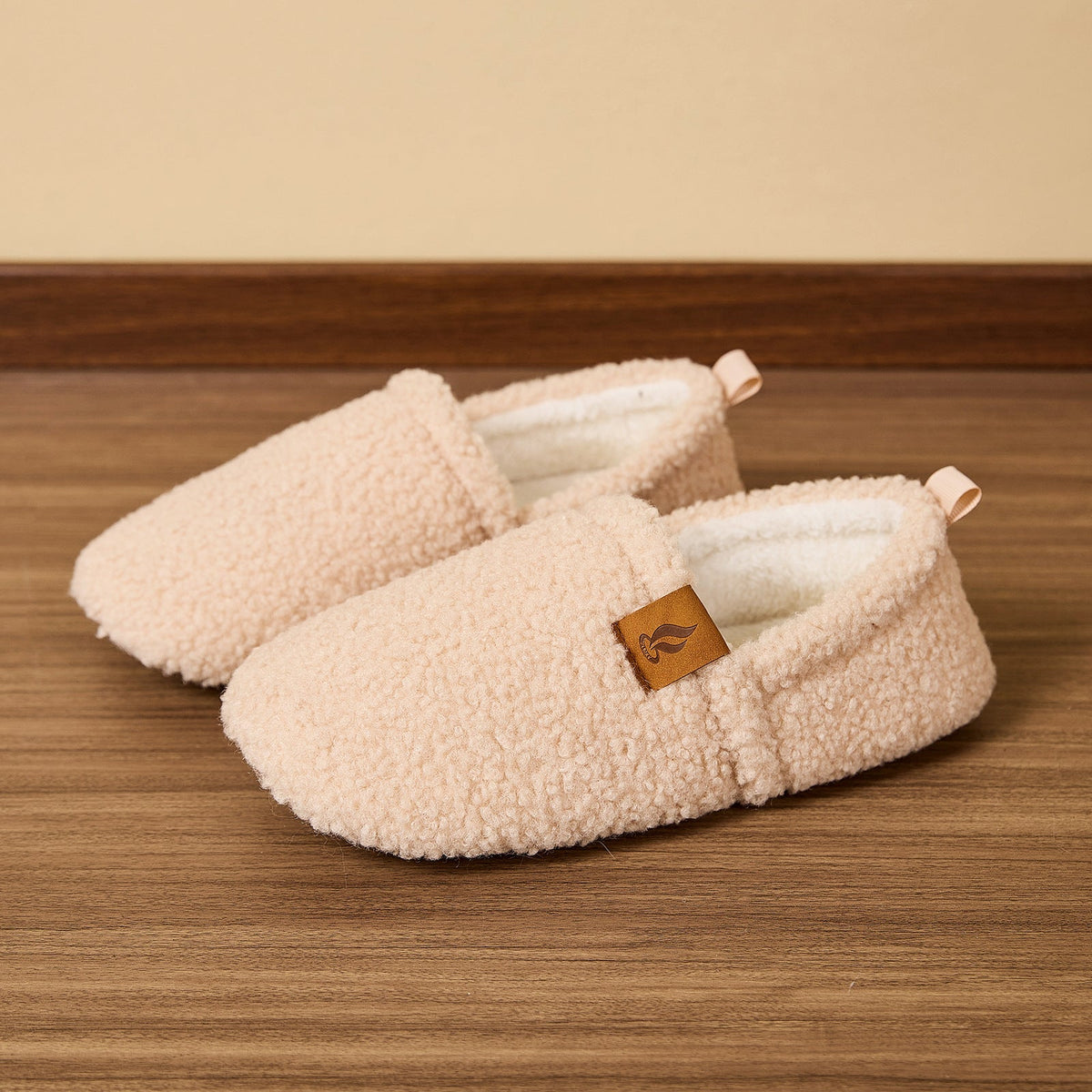 Auldweave women's warm shearling slippers – cream pair on a wooden floor