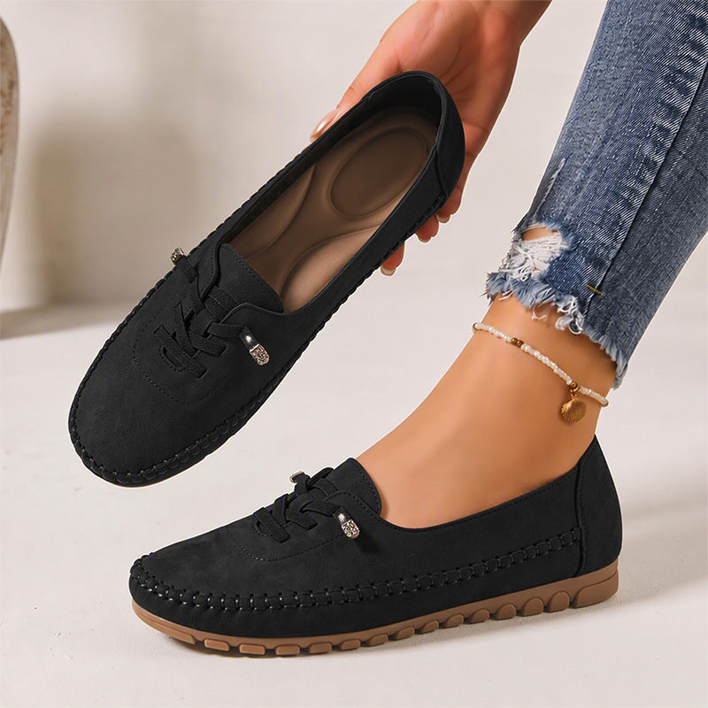 Black women's suede loafers showing the shaped insole and decorative lacing