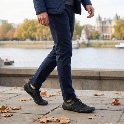 Jet black walking shoes worn during a city walk, side view