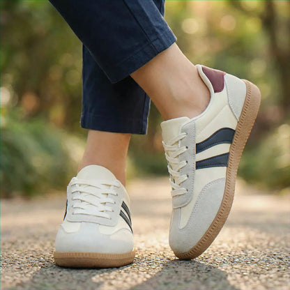 Cream and navy walking trainers, close on-foot outdoor view