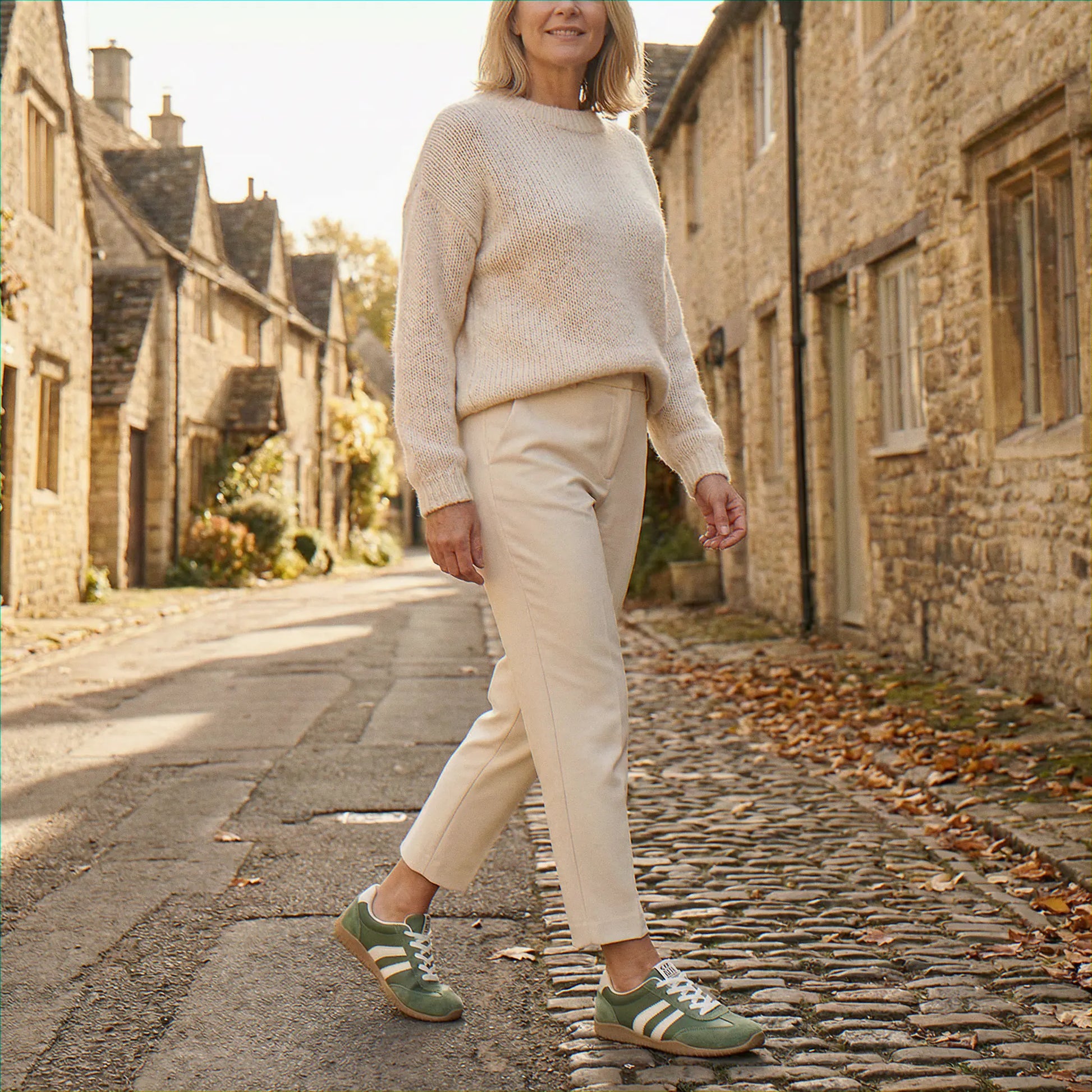 Woman wearing olive green trainers on a village street