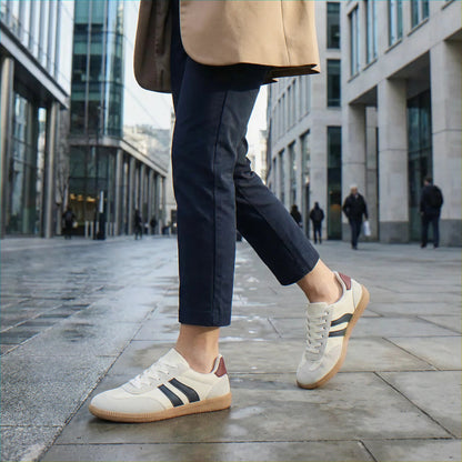Woman wearing cream and navy trainers in the city