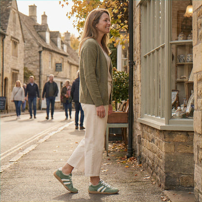 Woman wearing olive green trainers on a village street, view 35