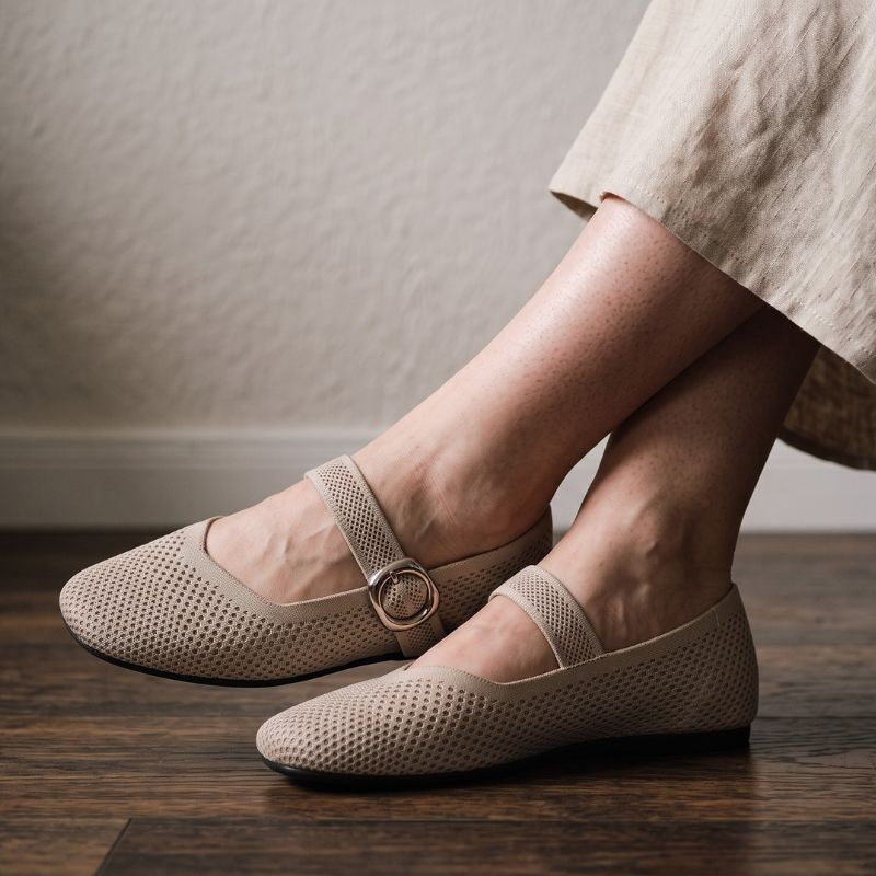 Beige Mary Jane flat shoes with square toe and buckle strap worn indoors, side view
