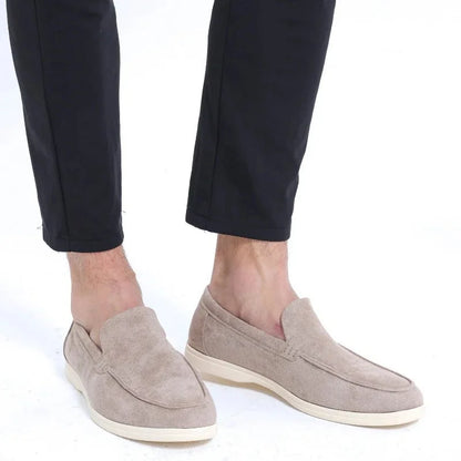 Light grey men's wide fit loafers worn with dark trousers