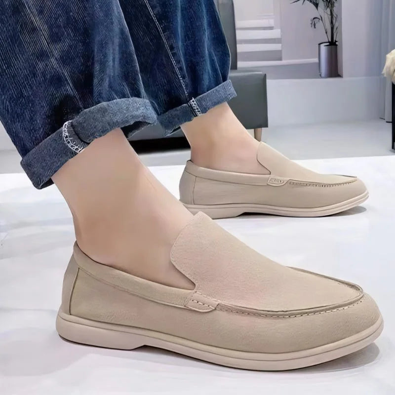 Light brown men's slip on loafers worn with rolled jeans, side view