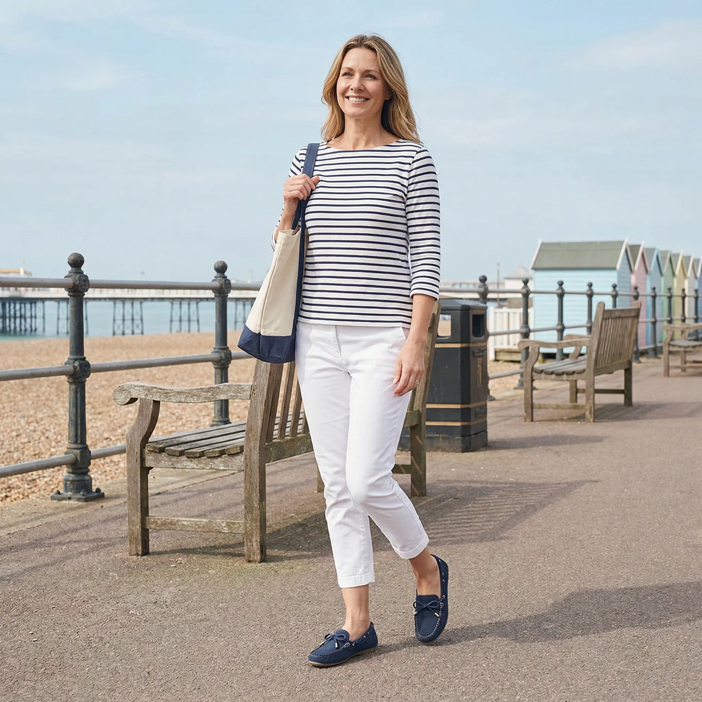 Woman wearing navy loafers on a seaside promenade