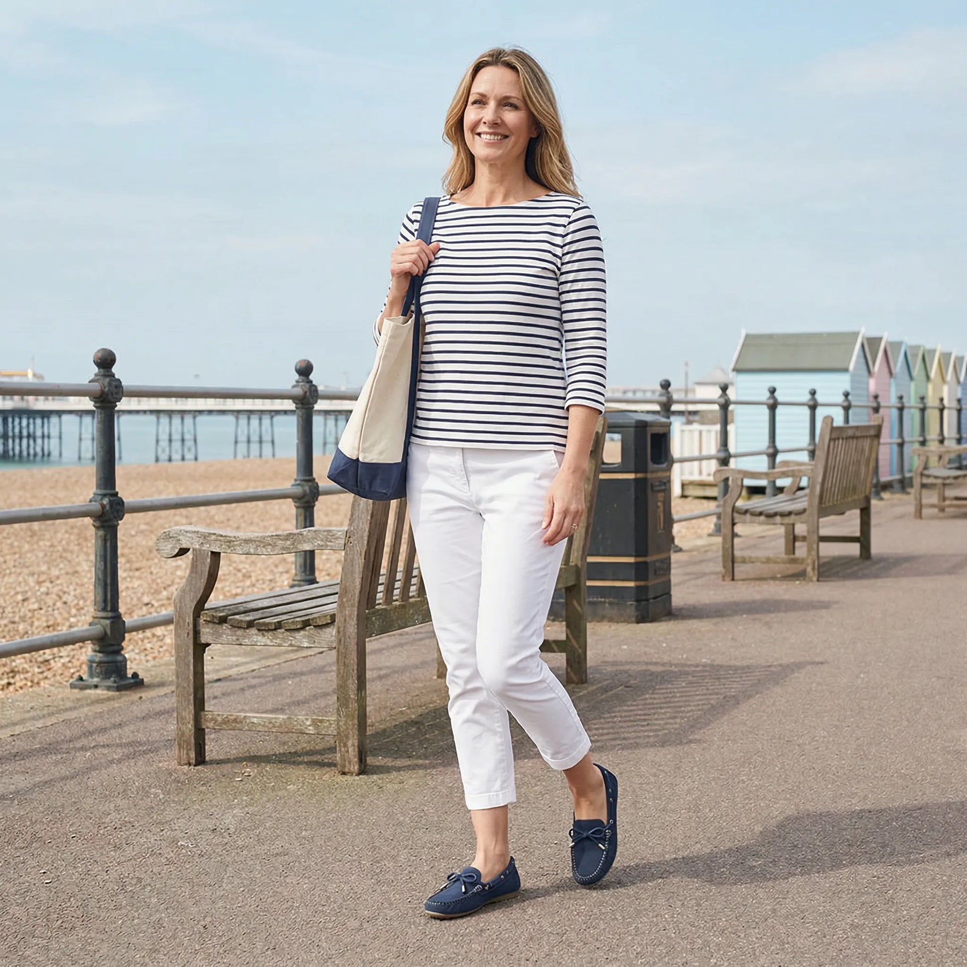 Woman wearing navy loafers on a seaside promenade