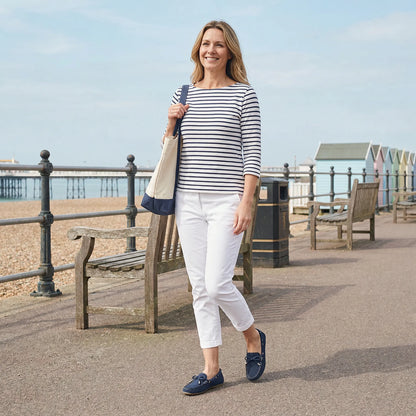 Woman wearing navy loafers on a seaside promenade