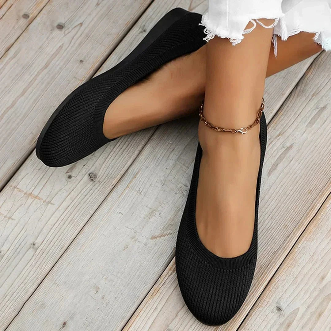 Women's black knit loafer flats shown on foot