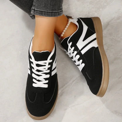 Black retro trainers for women, close on foot studio view