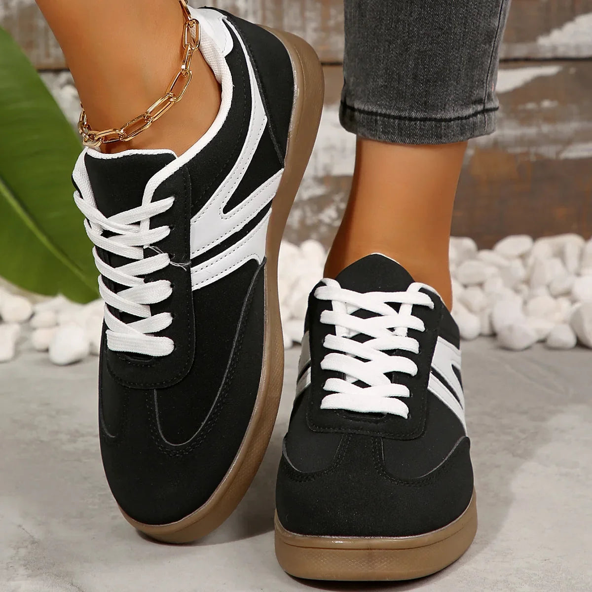 Black walking trainers for women, front on foot studio view