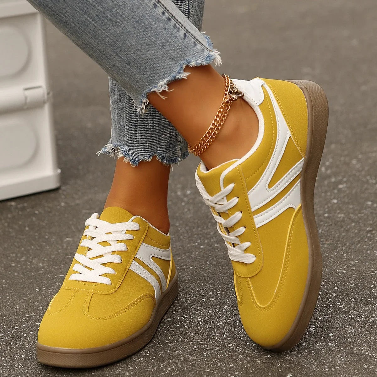 Yellow retro trainers for women, top down on foot street view