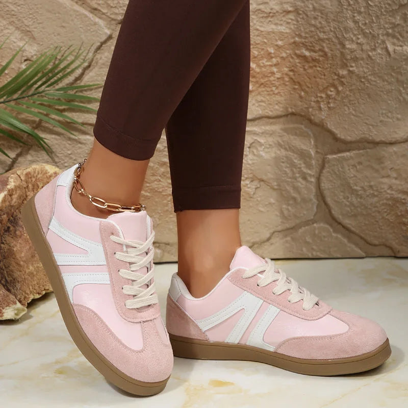 Pink wide fit trainers for women, angled on foot studio view