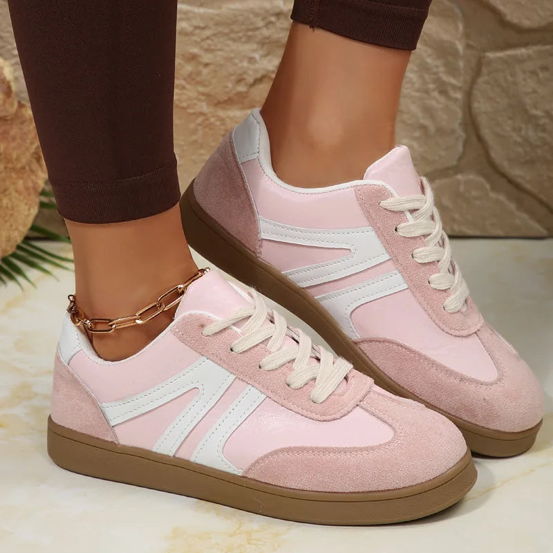 Pink retro trainers for women, side on foot studio view