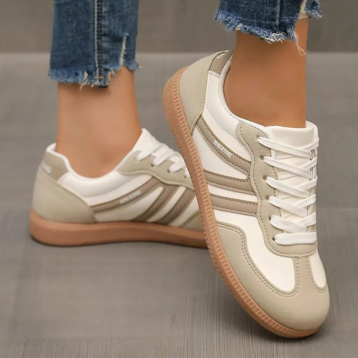 Women's beige and white retro trainers worn in a front three quarter view