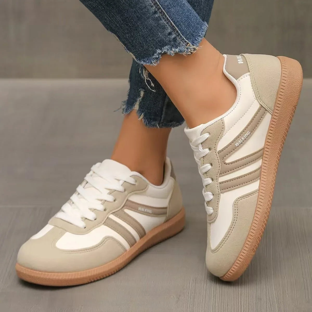 Women's beige and white retro trainers worn at opposing angles