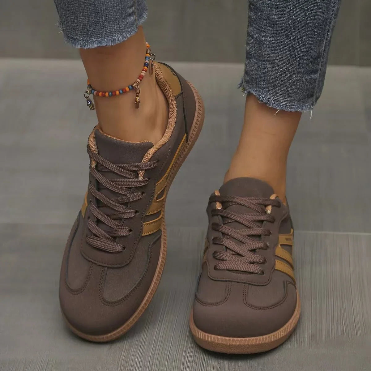 Women's brown and tan retro trainers worn from the front