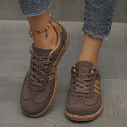 Women's brown and tan retro trainers worn from the front