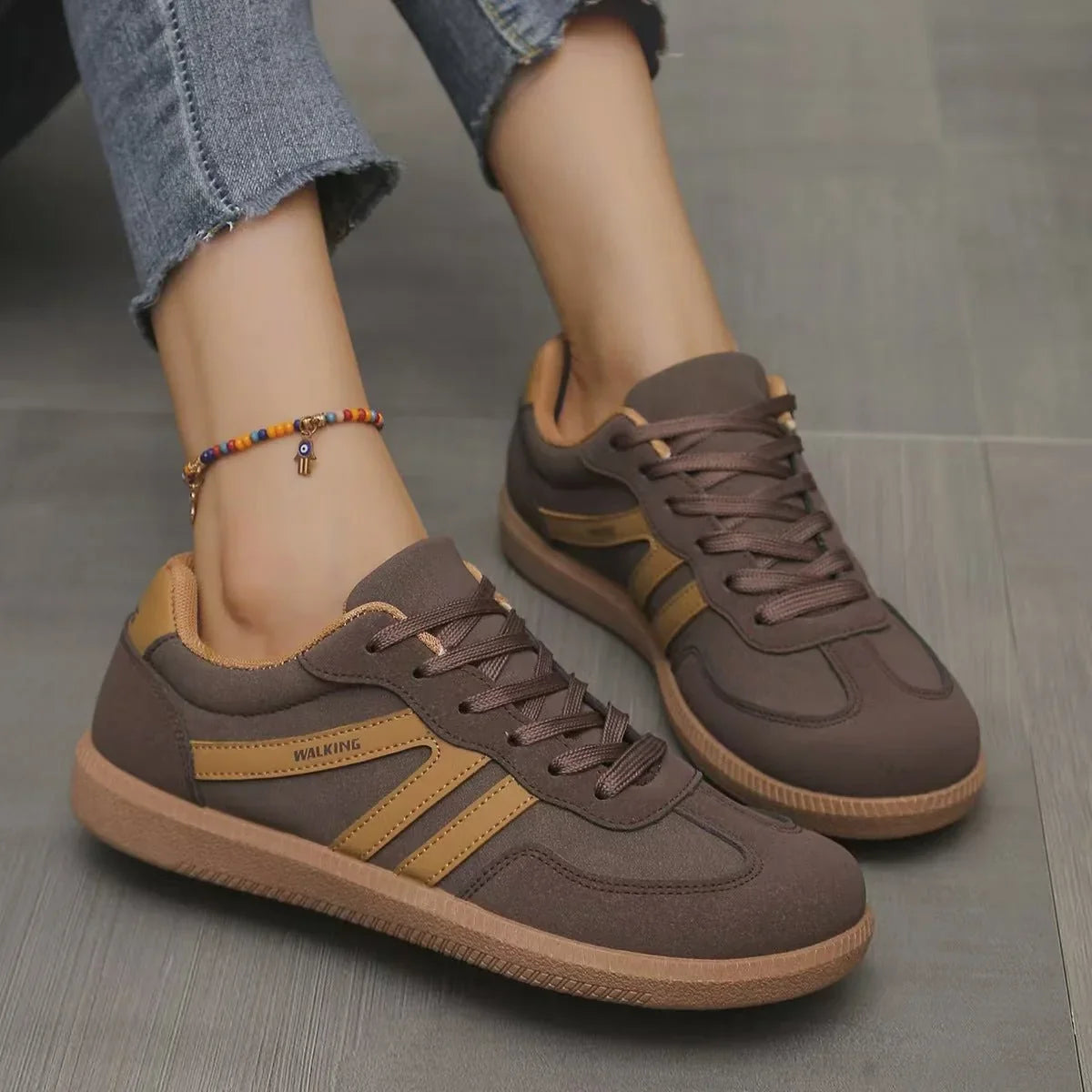 Women's brown and tan retro trainers worn in side profile