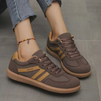 Women's brown and tan retro trainers worn in side profile