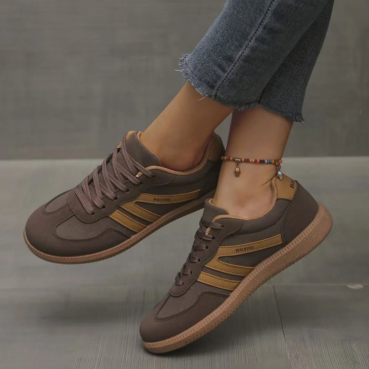 Women's brown and tan retro trainers worn from the side