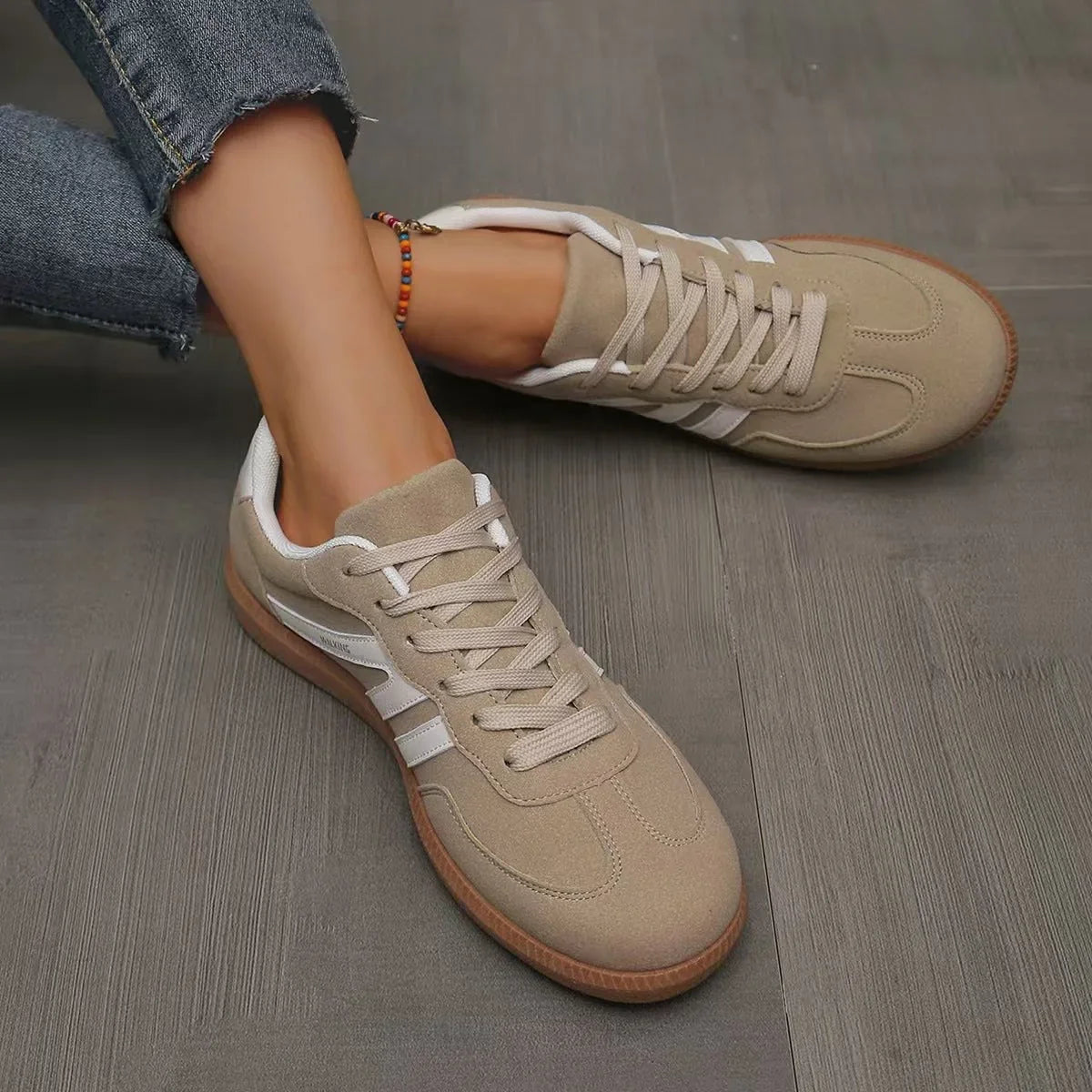 Women's beige and white retro trainers viewed from above on foot