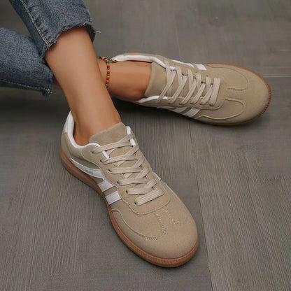 Women's beige and white retro trainers viewed from above on foot